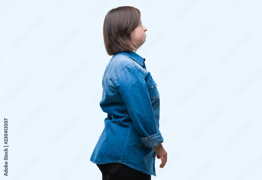 Young adult woman with down syndrome over isolated background looking to side, relax profile pose with natural face with confident smile. Young adult woman with down syndrome over isolated background looking to side, relax profile pose with natural face with confident smile.