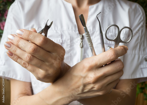 Manicure tool in the hands of the master. Close up. 