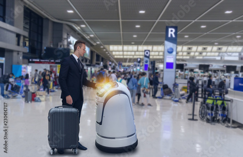 Smart robotic technology concept, The passenger follow a service robot to a counter check in in airport, the robot can help and give some information to passenger quickly photo