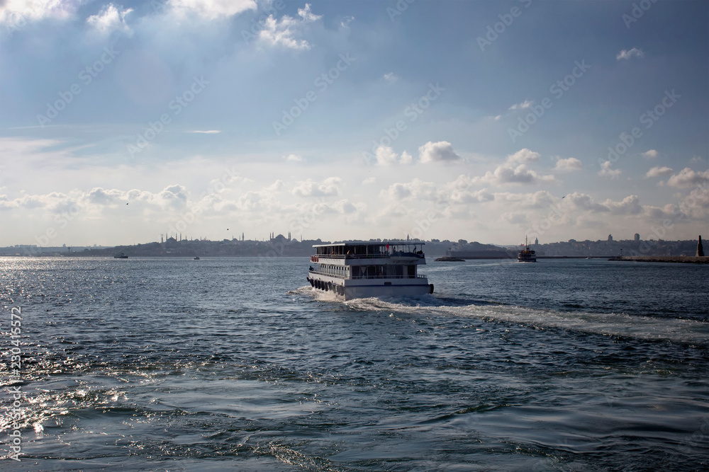 View of public ferry boat, Bosphorus strait and European side of Istanbul in a sunny summer day.