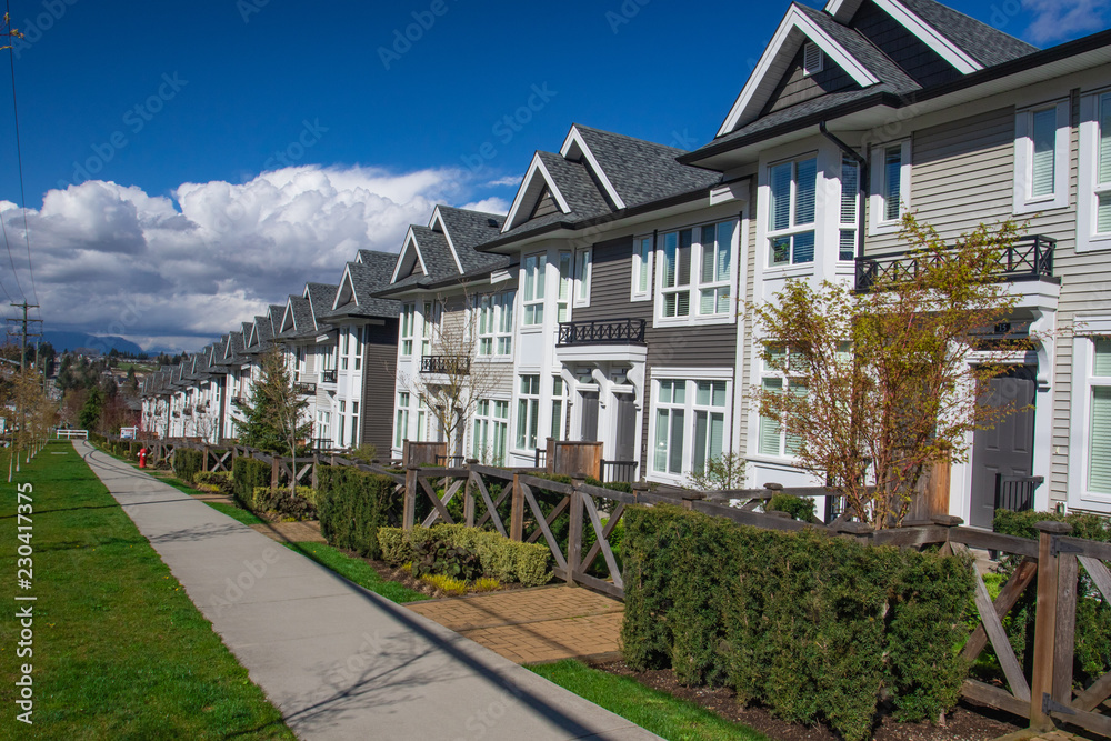 Suburban residential street townhomes. On bright sunny spring day against bright blue sky.