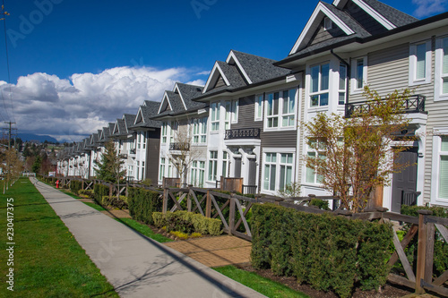 Suburban residential street townhomes. On bright sunny spring day against bright blue sky.