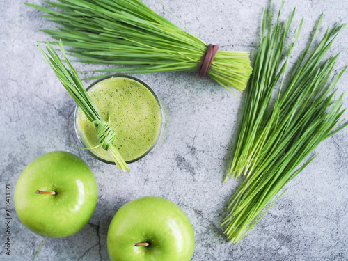 Detox juice mix between wheat grass and apple on top view. Nutrition food concept. Healthy drinking.