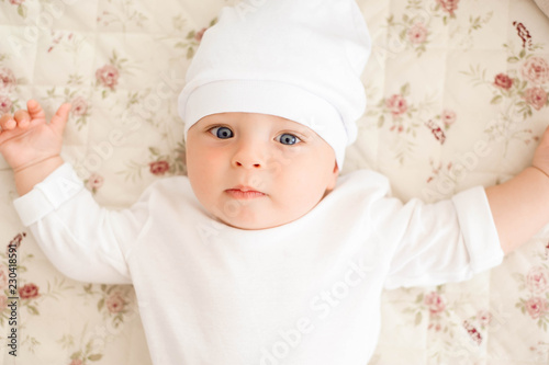 Portrait of a crawling baby on the bed in her room