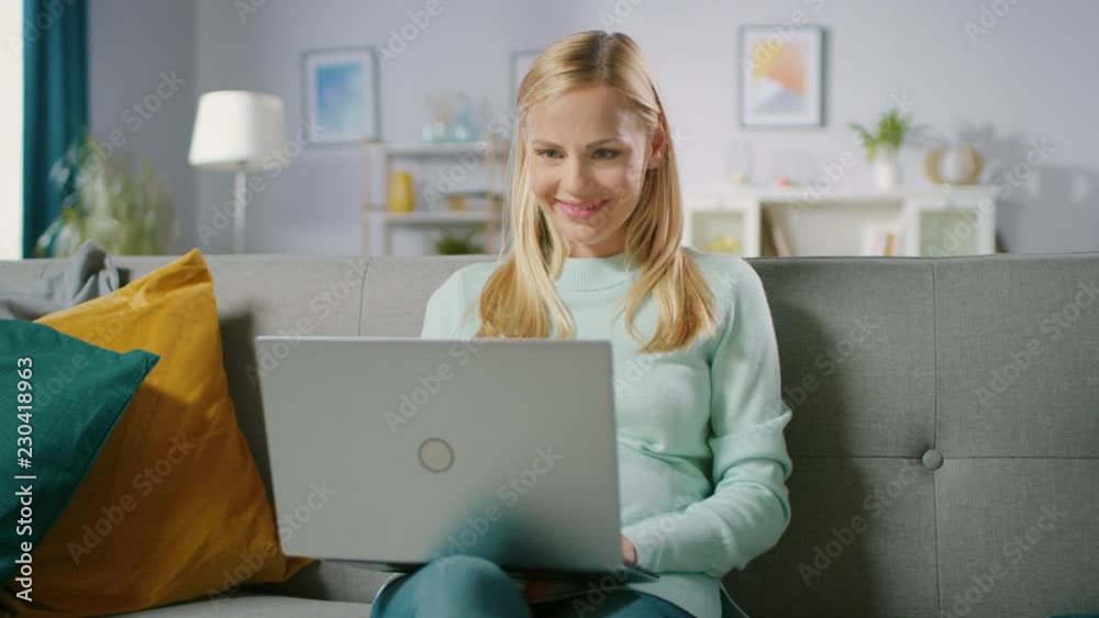 Happy Pregnant Woman Resting on a Sofa Uses Laptop Computer. Smiling Beautiful Future Mom Does Internet Shopping on Computer. Happy Pregnant Woman Resting on a Sofa Uses Laptop Computer. Smiling Beautiful Future Mom Does Internet Shopping on Computer.