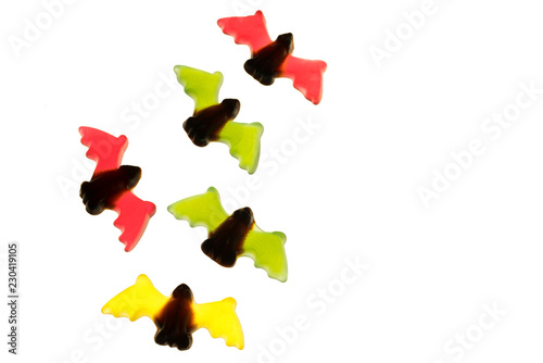 multicolored gummy jelly bat candies over white background