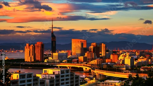 Fukuoka, Japan. A sunset video with a view of central Fukuoka, Japan, with tall modern buildings standing by the Hakata Bay on a cloudy summer day. Time-lapse from day to night