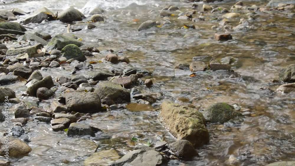 water flowing on the rock and wave splashing in river water flowing on the rock and wave splashing in river