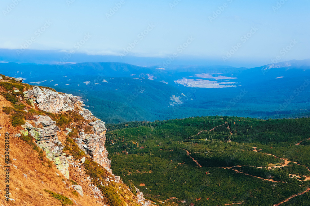 Amazing mountain valley landscape,  alpine hiking trail, green meadows, rocky hill spur.