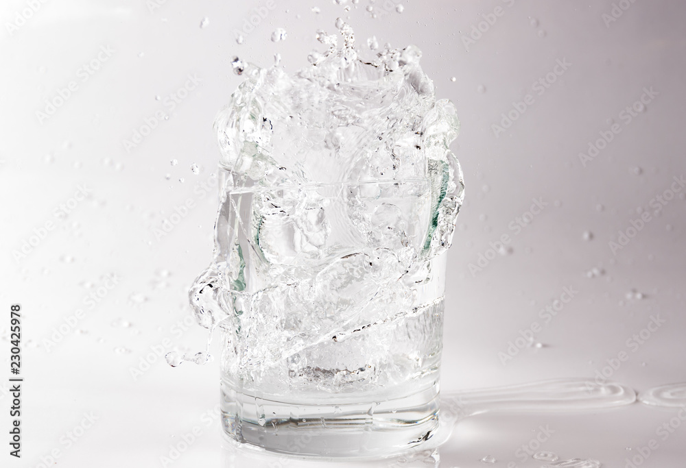 Falling and crashing glass of water. Shards of glass and splashing water Falling and crashing glass of water. Shards of glass and splashing water