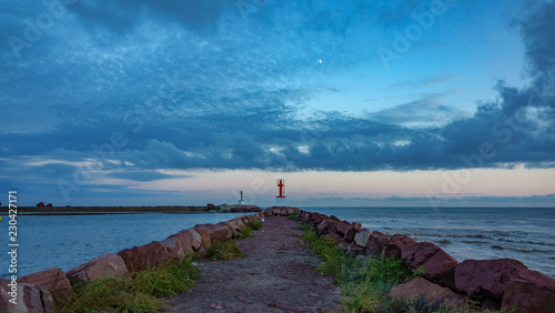 Marina mouth entrance and lighthouse at dusk in breakwater