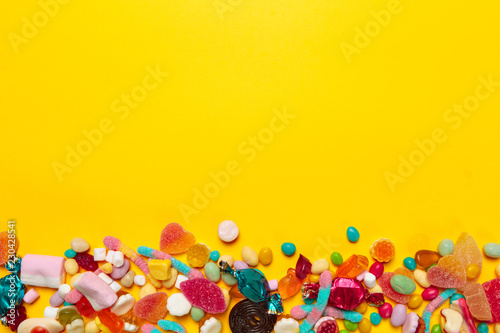 colored candies on yellow background © fotofabrika
