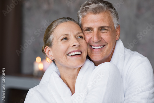 Laughing senior couple embracing at spa