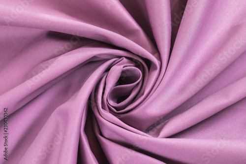 The monophonic fabric of lilac color showing a beautiful drapery a spiral.