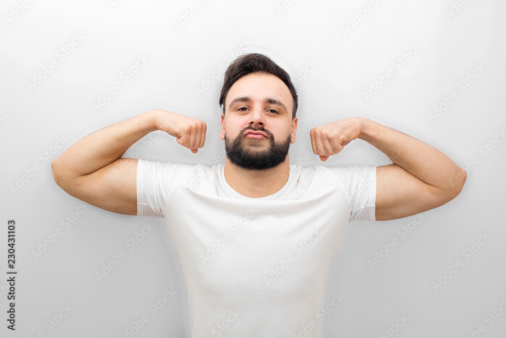 Well-built and strong young man stands and poses on camera. He has good figure and muscles. Isolated on white background. Well-built and strong young man stands and poses on camera. He has good figure and muscles. Isolated on white background.