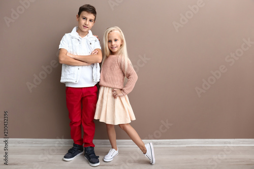 Cute boy and girl in fashionable clothes near color wall © Pixel-Shot