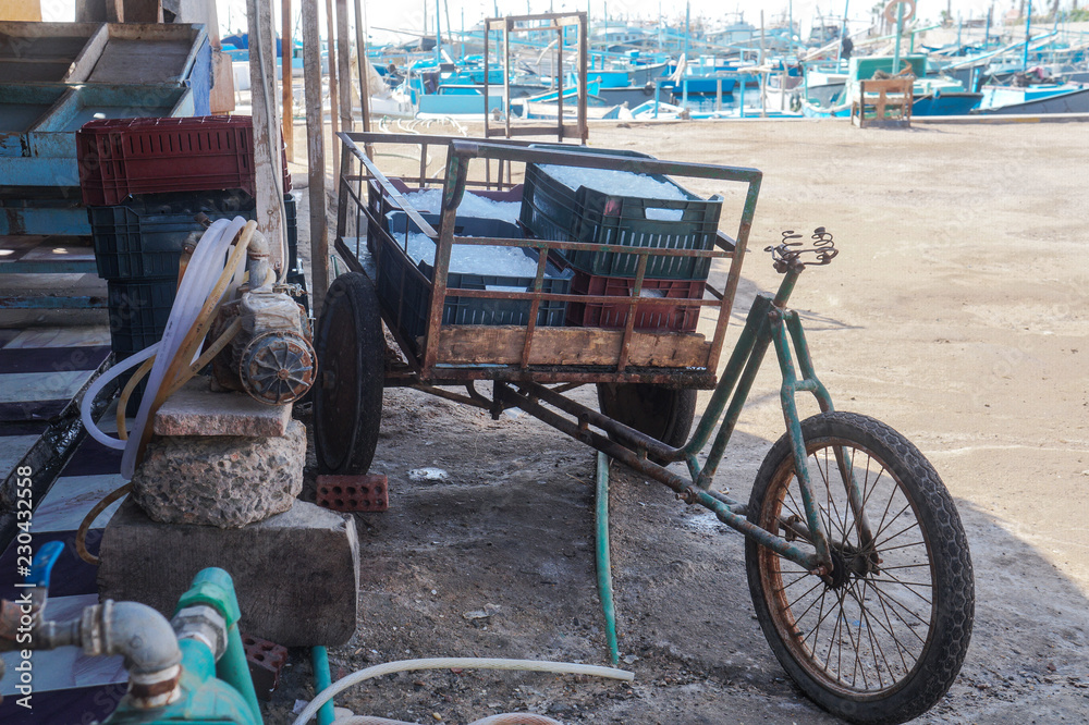 An old broken bike loaded with ice crates in the tropics. Egyptian market in all its glory. Slum poverty