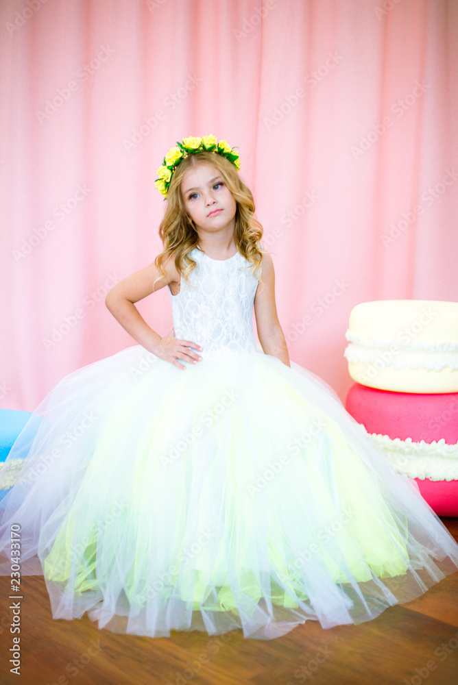 Cute little girl with blond curls in a white lush dress with giant ...
