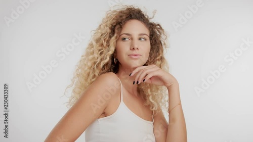 beauty model with curly blond hair blowing in air streaming in air photo