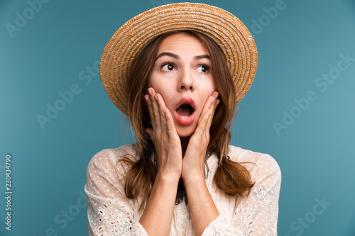 Portrait of a young shocked girl in summer hat