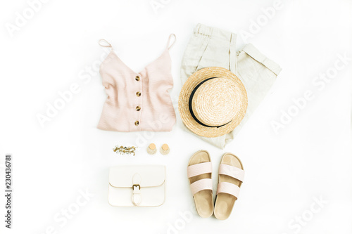 Flat lay, top view travel fashion look with woman clothes and accessories on white background.