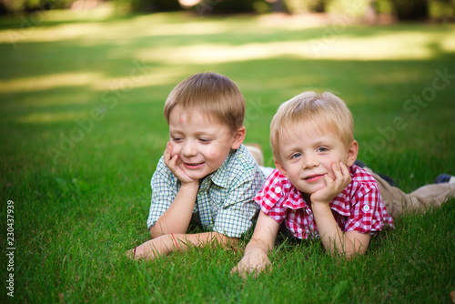 Two young boys walk and relax in the park.