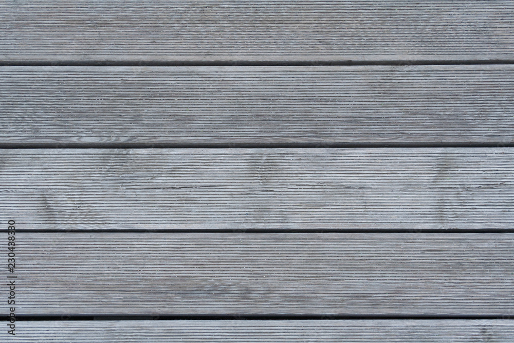 Horizontal gray wooden planks with ribbed surface as texture, background Horizontal gray wooden planks with ribbed surface as texture, background