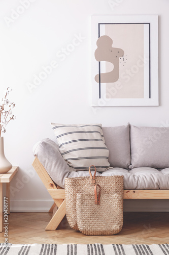 Abstract painting on the wall of natural beige living room with grey settee in lagom inspired interior