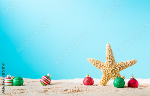 Starfish with Christmas ornaments on a beach sand