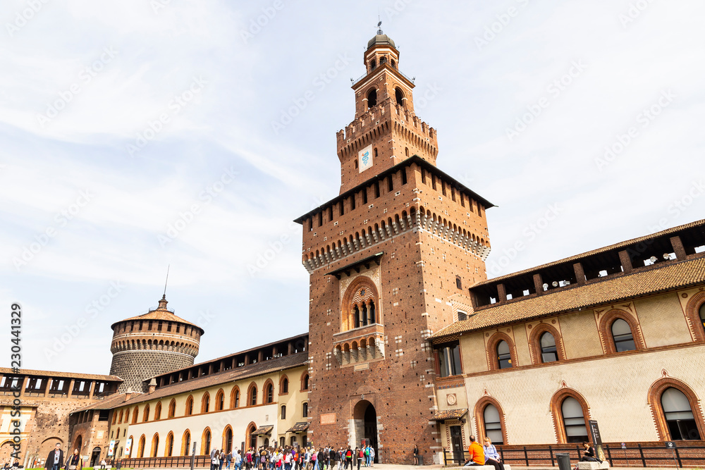 Traveler at front gate of Sforza Castle (Castello Sforzesco) is a castle in Milan, Italy