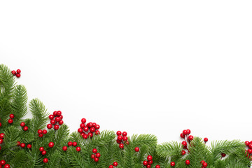 Christmas and New Year's composition. Top view of spruce branches, pine cones, red berries and bell on white background.