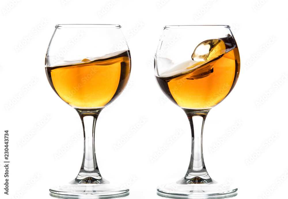 A round glass with brandy and a splash of drink inside A round glass with brandy and a splash of drink inside