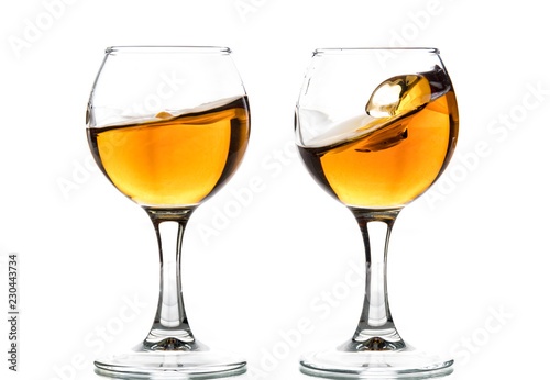 A round glass with brandy and a splash of drink inside © Vasily Popov