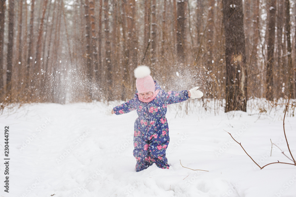 Childhood and nature concept - Adorable child playing in winter park Childhood and nature concept - Adorable child playing in winter park