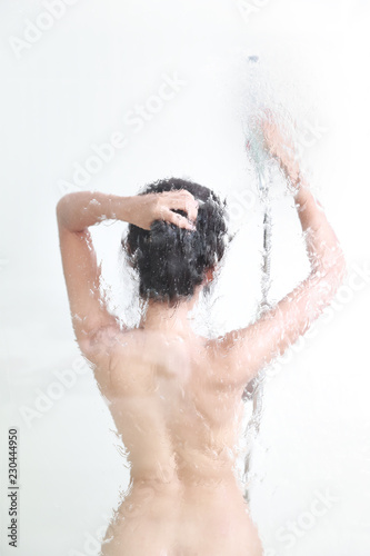 blurred image of beautiful and sexy woman taking shower from back view