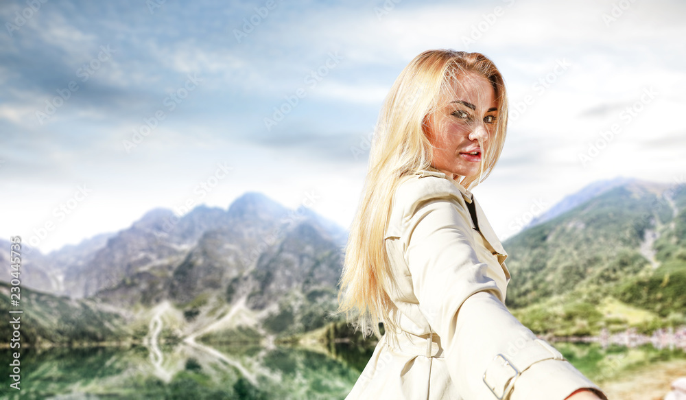 Slim young blond woman and autumn landscape of mountains. 