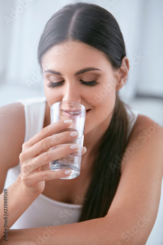 Happy Woman Drinking Water. Beautiful Female With Glass Of Water