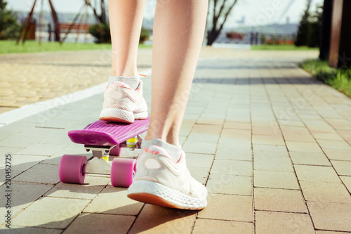 Close up. Sporty child having active day and testing her longboard