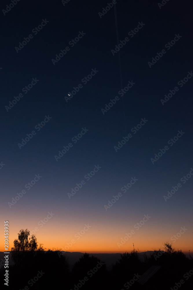 Sunrise in nature, with the moon shining in the sky Sunrise in nature, with the moon shining in the sky