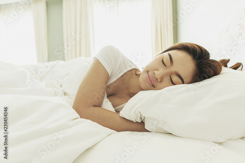 Beautiful Attractive Asian woman sleep and sweet dream on bed in bedroom in the morning,Healthcare Concept,Warm Tone