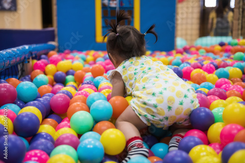 little girl having fun in ball pool photo