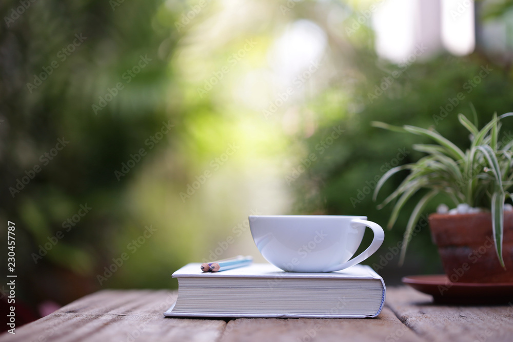 White cup with plant and notebooks White cup with plant and notebooks