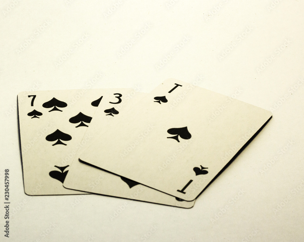 Obraz premium Three cards, seven and ace of peaks lie on a white background
