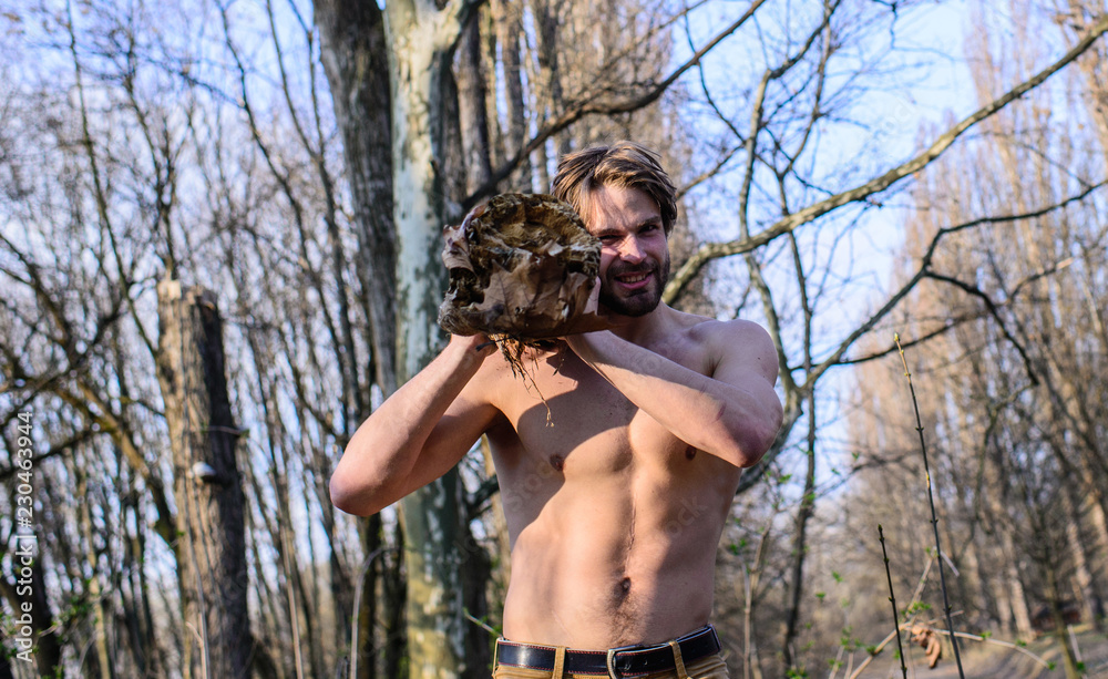 Hermit lifestyle. Man brutal sexy lumberjack carry big log on shoulder. Man  brutal strong attractive guy collecting wood in forest. Lumberjack or woodman  sexy naked muscular torso gathering wood Stock Photo