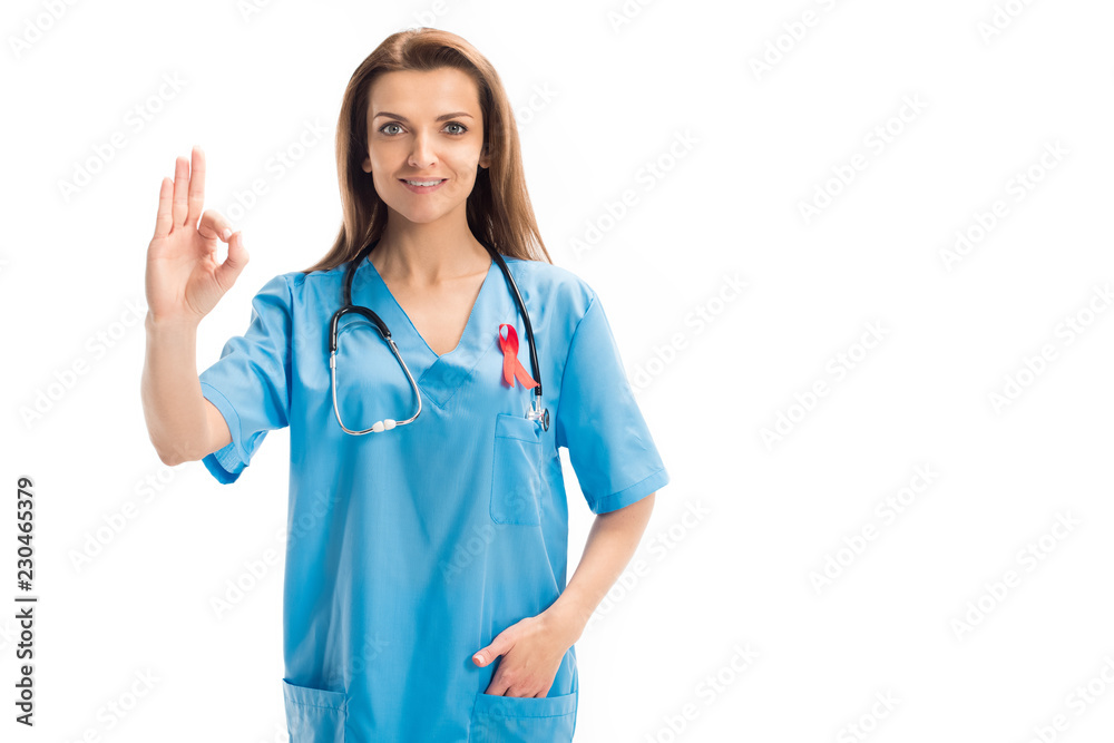 attractive doctor with red ribbon showing okay gesture isolated on white, world aids day concept attractive doctor with red ribbon showing okay gesture isolated on white, world aids day concept