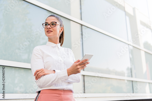 Caucasian businesswoman using smartphone outdoor