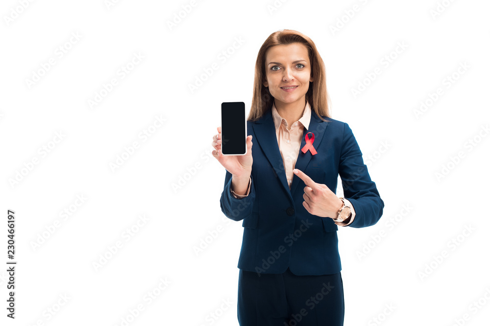 attractive businesswoman with red ribbon on suit pointing on smartphone with blank screen isolated on white, world aids day concept attractive businesswoman with red ribbon on suit pointing on smartphone with blank screen isolated on white, world aids day concept