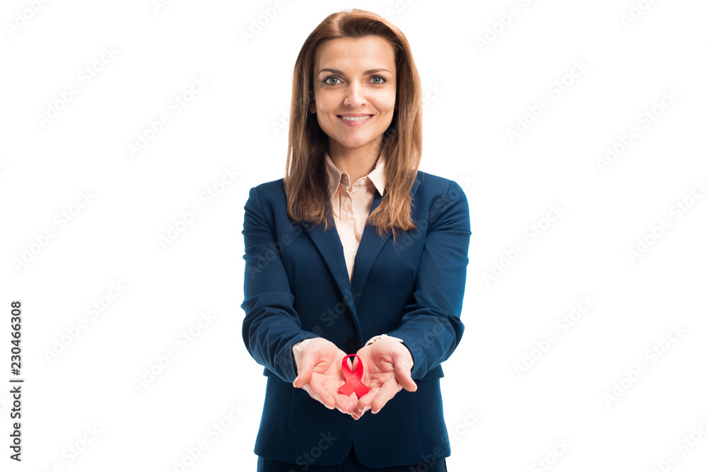 attractive smiling businesswoman holding red ribbon in hands and looking at camera isolated on white, world aids day concept attractive smiling businesswoman holding red ribbon in hands and looking at camera isolated on white, world aids day concept