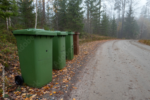 four trash cans beside a gravel road near Nykroppa sweden