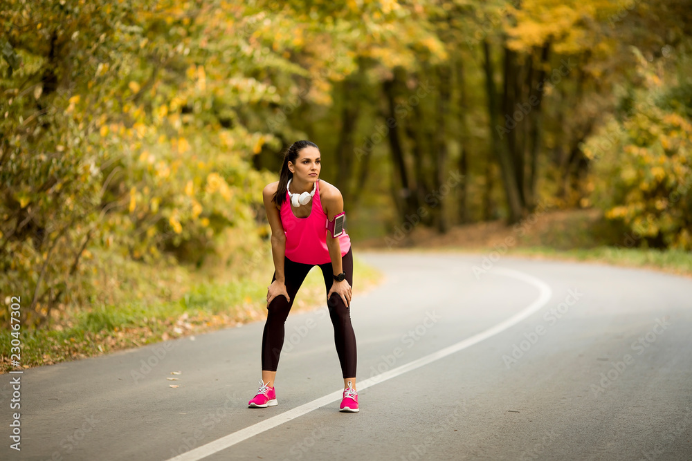 Young woman have a break during training in the autumn forest Young woman have a break during training in the autumn forest